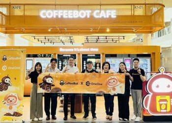 Representatives from CoffeeBot and ONEVERSE celebrate the partnership.